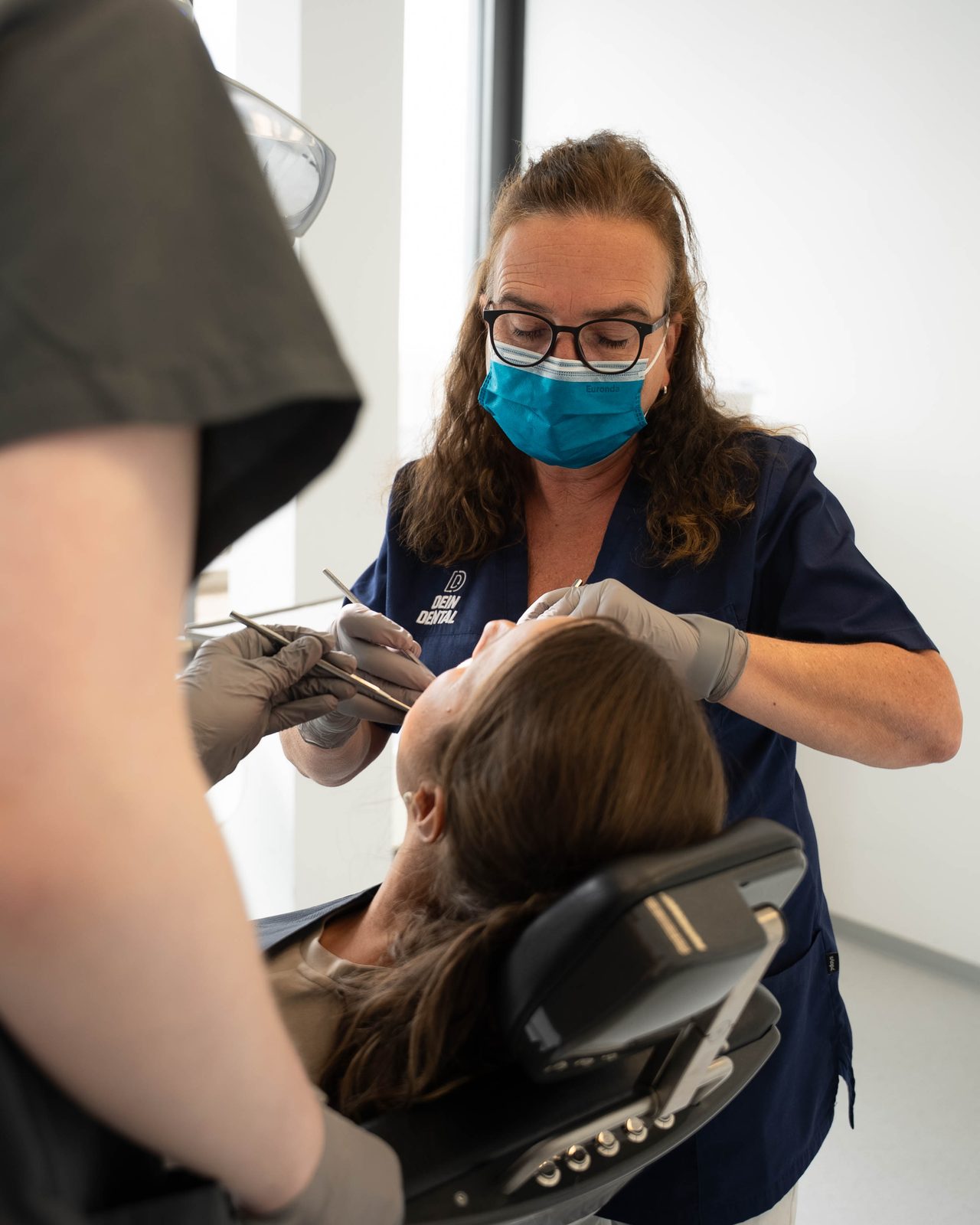 Zahnärztin bei DEIN DENTAL Karlsruhe bei der Behandlung, mit Assistenz
